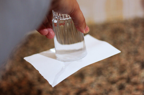 لماذا عندما نضع ورق على كأس به ماء و نقلب الكأس لا يسقط الماء بفعل الجاذبية ؟